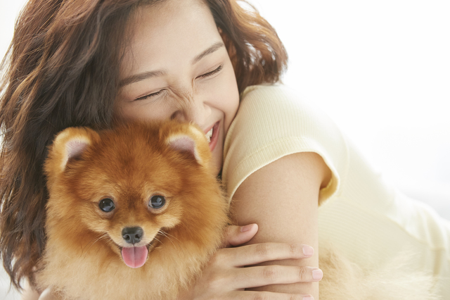 小型犬を抱きしめる女性