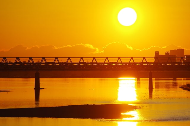 朝焼けと多摩川橋梁を通過する京王線