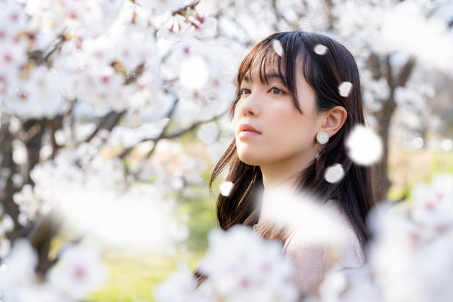 桜吹雪の中に佇む女性