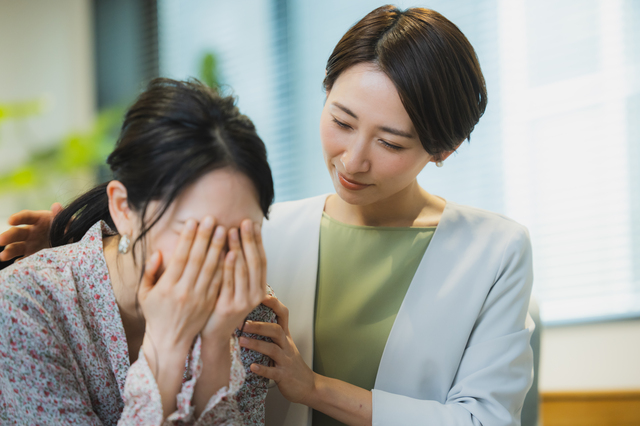 泣いている女性と励ます女性
