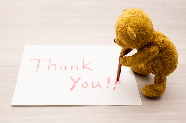 Thank youと紙にかくクマのぬいぐるみ