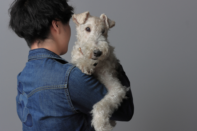 犬を抱く男性