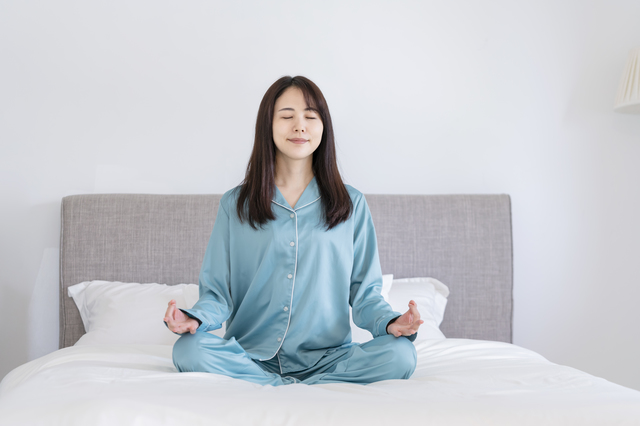ベッドで瞑想する女性