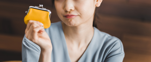 黄色い財布を見つめる女性