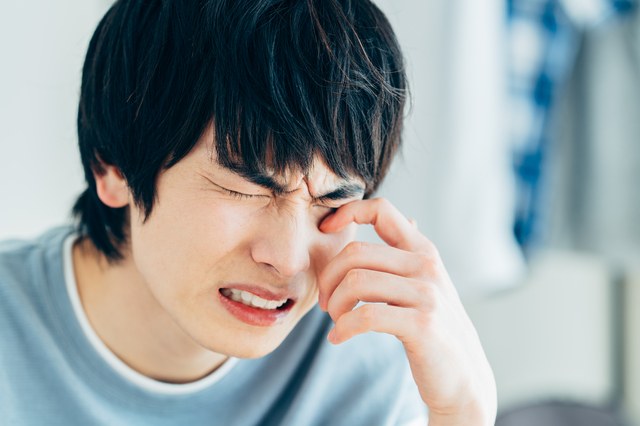 花粉症で目がかゆい男性