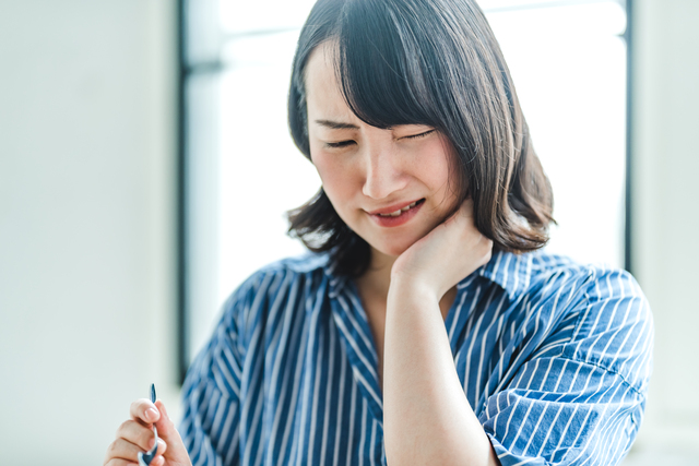 歯の痛みを我慢している女性