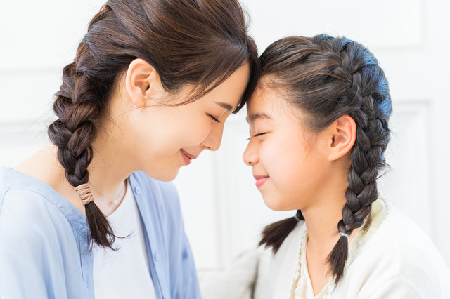目を閉じて額を合わせる親子