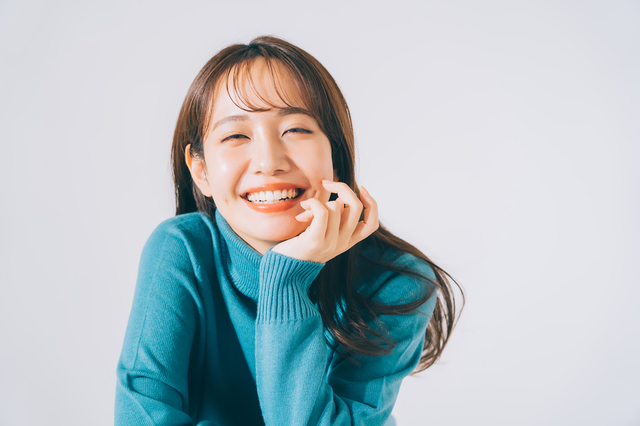 青いニットを着る女性