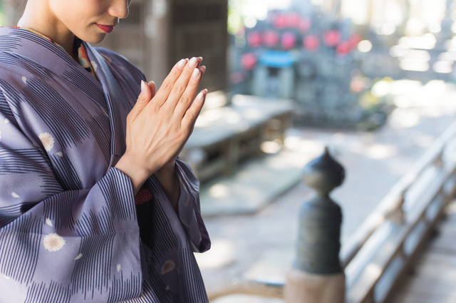 お寺を参拝する着物の女性