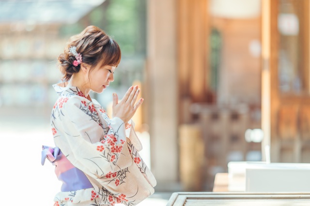 浴衣でお参りをする女性