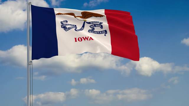 Flag of Iowa - US state fluttering in the wind against a cloudy sky 3d rendering