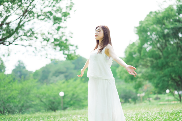 自然の中で深呼吸をする女性