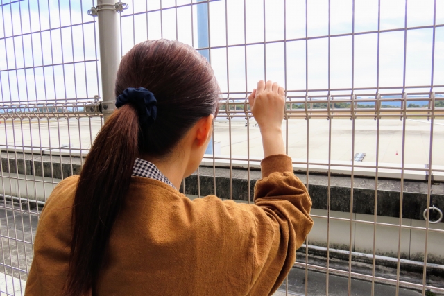 飛行機をみる女性