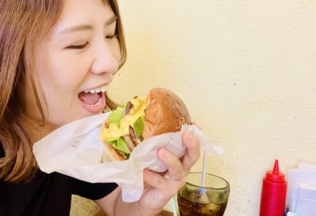 ハンバーガーを食べる女性