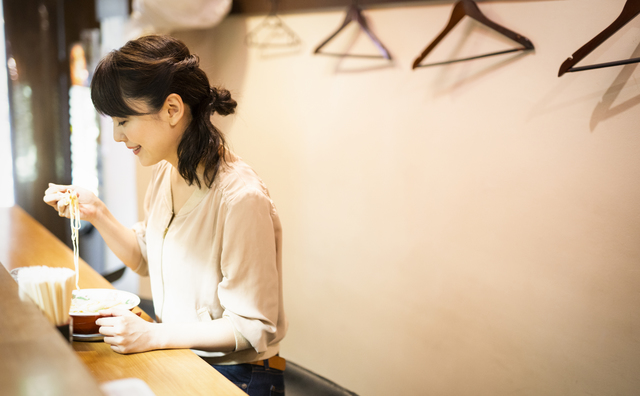 一人でラーメンを食べる女性