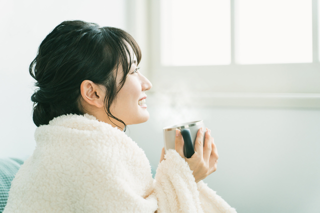 温かい飲み物を飲む女性