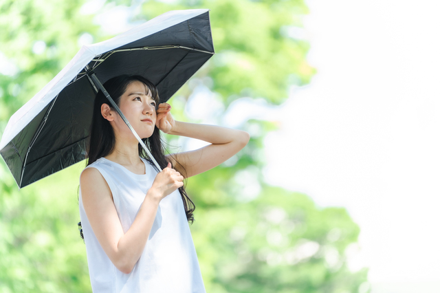 日傘をさす女性　暑い