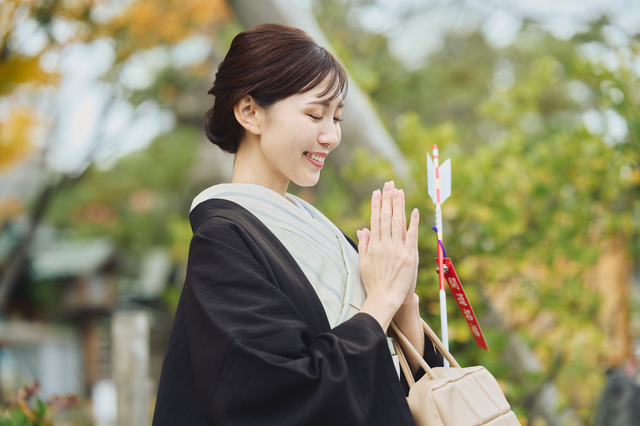 神社で手を合わせる人