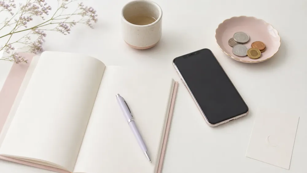 電話占いの料金を確認するためのスマートフォンとノート