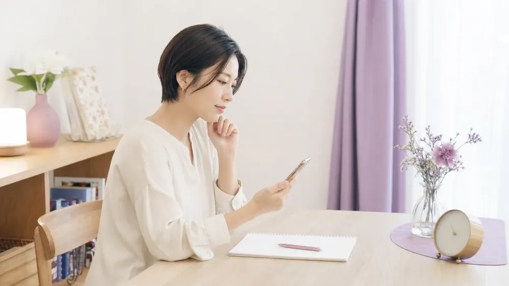 電話占いの相談時間を考えながらメモを準備する女性